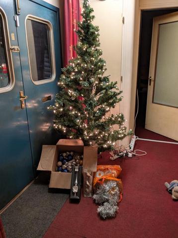Een complete kerstboom met kerstballen, slingers en lampjes beschikbaar voor biedingen