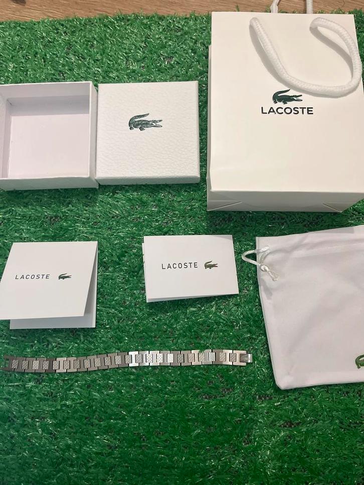 Merk Lacoste .Armband Nieuw met complete verpakking!, Sieraden, Tassen en Uiterlijk, Armbanden, Nieuw, Staal, Zilver, Ophalen of Verzenden