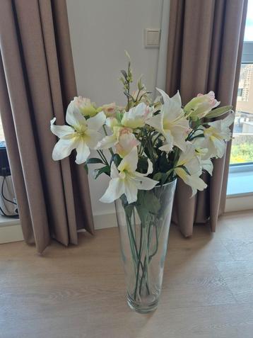 Hoge glazen vaas met kunstbloemen beschikbaar voor biedingen