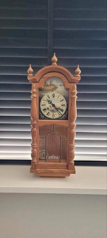 Houten wandklok met slinger beschikbaar voor biedingen
