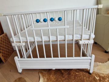 Op hoogte verstelbare box met wieltjes en matras beschikbaar voor biedingen