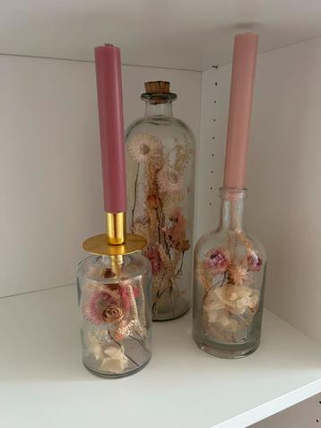 Glazen flessen met gedroogde bloemen erin beschikbaar voor biedingen