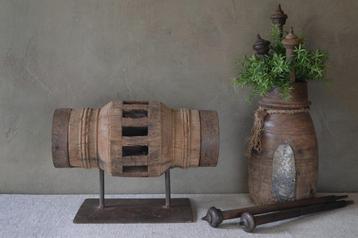 Oude houten wielas op standaard beschikbaar voor biedingen