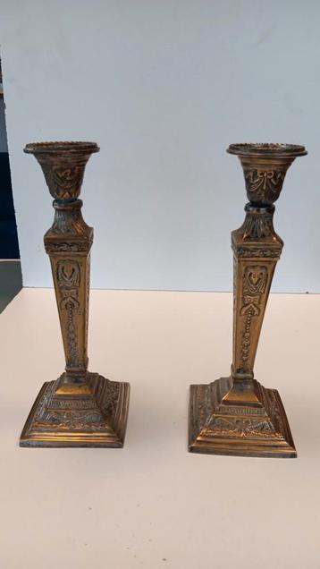 een paar vintage kandelaars met een verhoogd reliëfontwerp.  beschikbaar voor biedingen