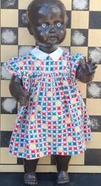 Negroïde pop met blauwe ogen. Orig. kleertjes.  58  cm., Ophalen, Gebruikt, Pop