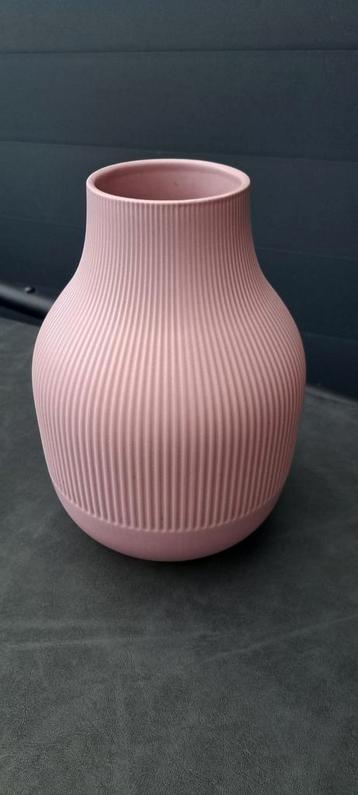Mooie roze keramieken vaas met een geribbeld patroon. beschikbaar voor biedingen