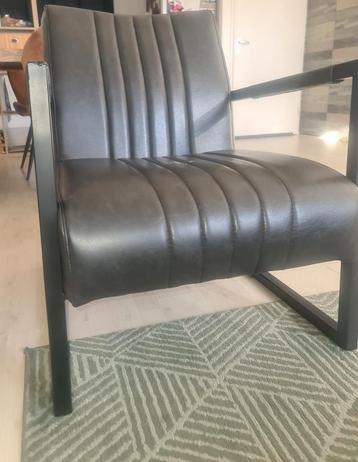 Zwarte fauteuil met beschadiging beschikbaar voor biedingen