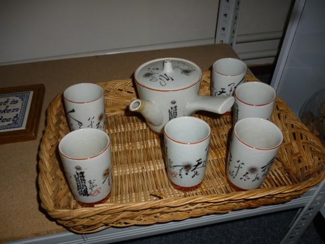 een mooi thee-servies op rieten schaal, Ophalen