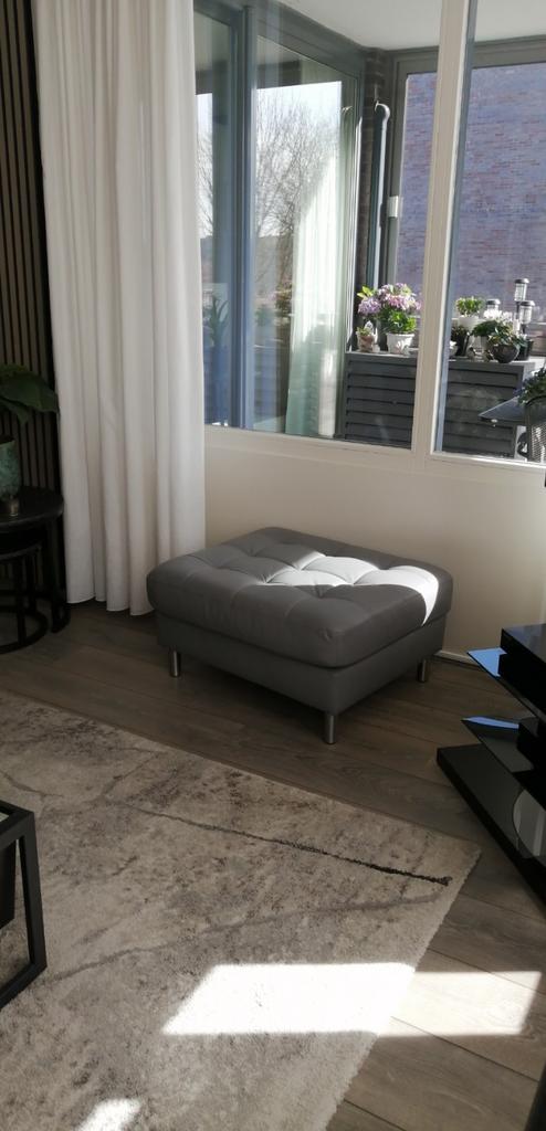 Mooie licht grijze leren hocker.