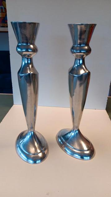 2 zilverkleurige hoge kandelaars.
 beschikbaar voor biedingen