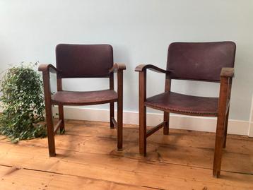 Twee houten stoelen met donkerrode skai leren bekleding beschikbaar voor biedingen
