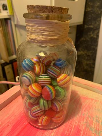 Gekleurde kralen in glazen fles beschikbaar voor biedingen