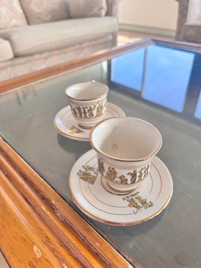 Kopjes en schotels met gouden rand en figuren, Ophalen of Verzenden