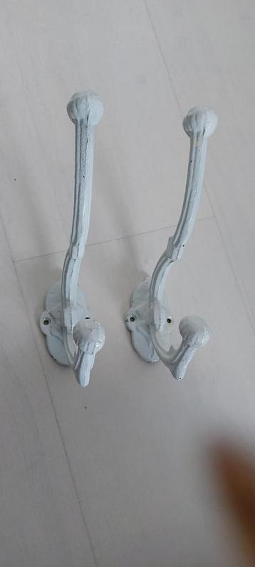 Twee witte ijzeren wandhaken beschikbaar voor biedingen