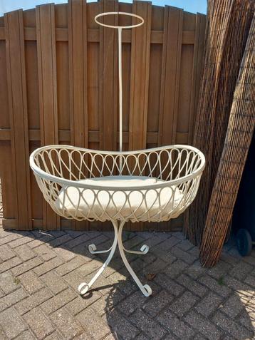 Rotan wieg op een smeedijzeren onderstel. beschikbaar voor biedingen