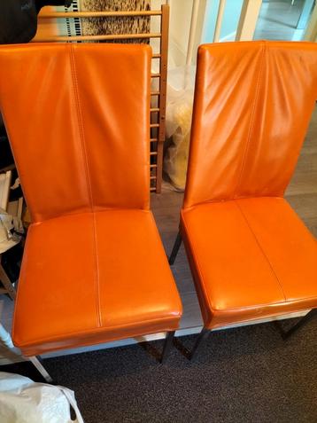 2 oranje  HVS, lederen eetkamerstoelen  beschikbaar voor biedingen