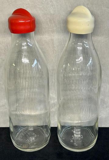 Twee oude glazen melkflessen beschikbaar voor biedingen