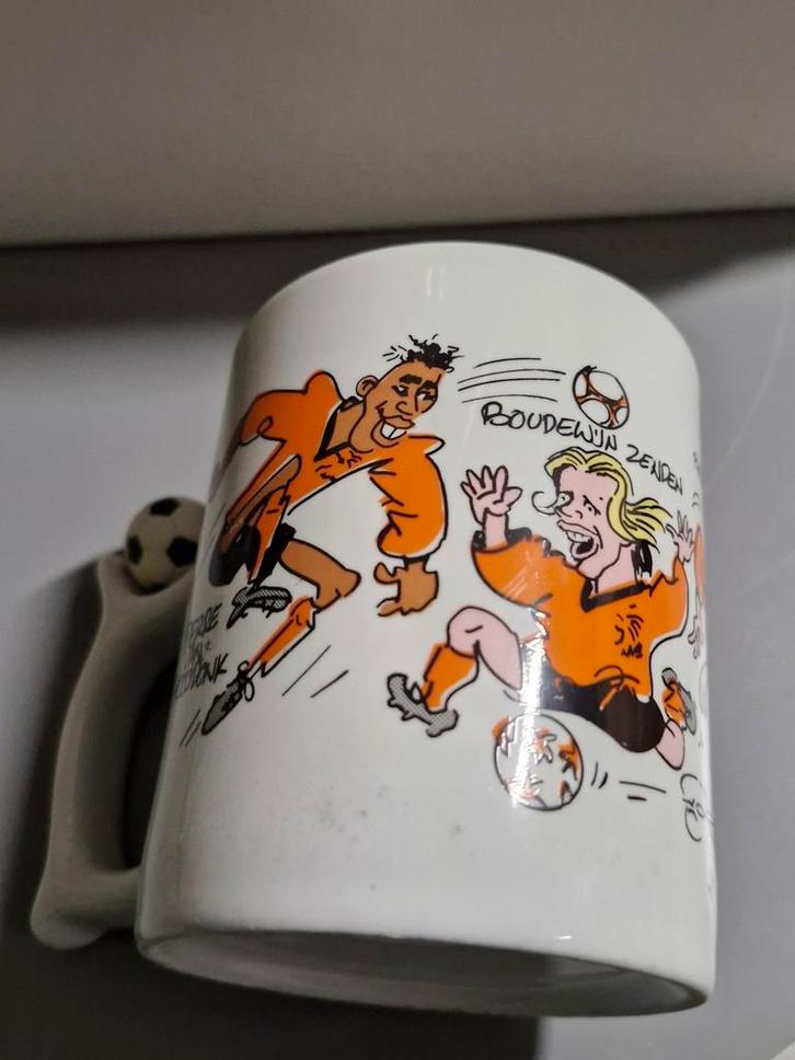 Oranje voetbal mok met cartoon figuren Van Dik Bruynesteyn, Verzamelen, Sportartikelen en Voetbal, Gebruikt, Overige typen, Ophalen of Verzenden