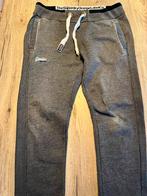 Te koop, grijze Superdry trainingsbroek maat M, Kleding | Heren, Maat 48/50 (M), Ophalen of Verzenden, Zo goed als nieuw, Grijs