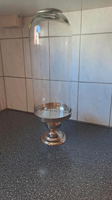 Hoge glazen stolp op zilverkleurige voet beschikbaar voor biedingen