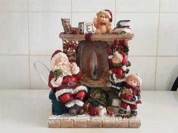 Kersttafereel kerstman bij de openhaard met verlichting  beschikbaar voor biedingen