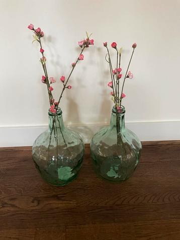 Groene glazen vazen met bloemen beschikbaar voor biedingen