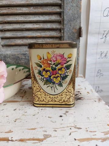 Goudkleurig blikje met viooltjes en andere bloemetjes beschikbaar voor biedingen