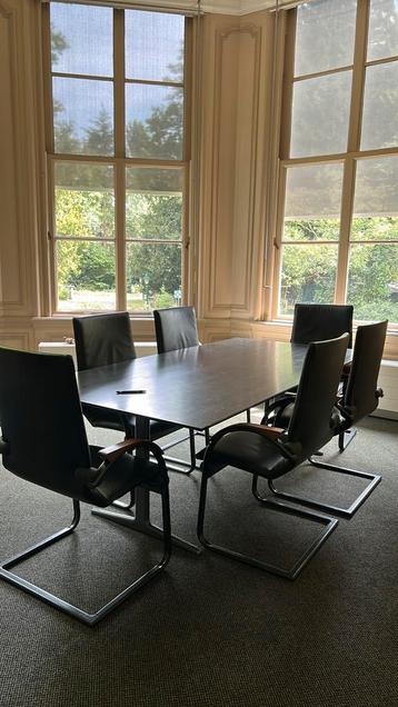 Grote vergadertafel met zes leren stoelen beschikbaar voor biedingen