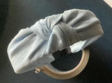Lichtblauwe stoffen haarband met knoop en witte details beschikbaar voor biedingen