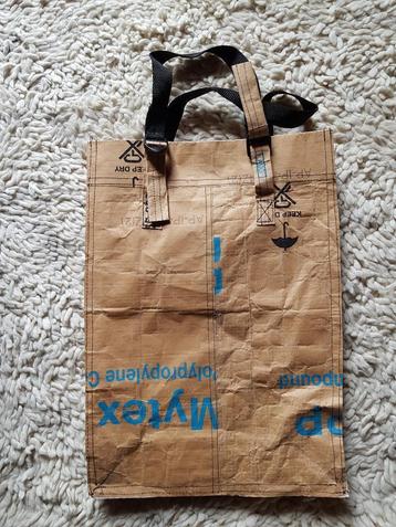 Geplastificeerde papieren tas, met handvat beschikbaar voor biedingen