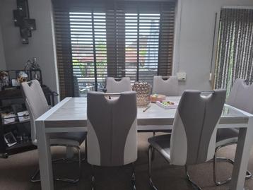 Massief houten eettafel met 6 trendy swingstoelen beschikbaar voor biedingen