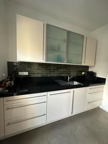 Moderne witte keuken met zwart gemailleerd blad.  Igs beschikbaar voor biedingen