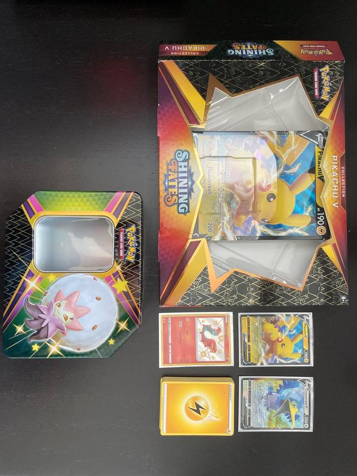 Pokémon Shining Fates Pikachu V Collection + Eldegoss Tin, Hobby en Vrije tijd, Verzamelkaartspellen | Pokémon, Zo goed als nieuw
