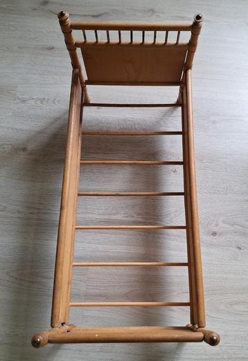 Een poppenbedje van hout beschikbaar voor biedingen