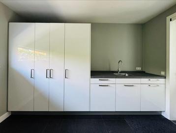 Moderne witte hoogglans keuken met wasmachine/drogerkast. beschikbaar voor biedingen