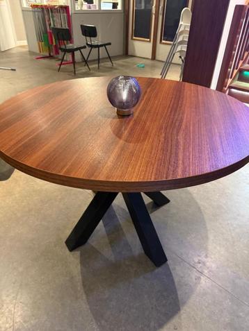 Ronde tafel met zwarte kruispoot beschikbaar voor biedingen