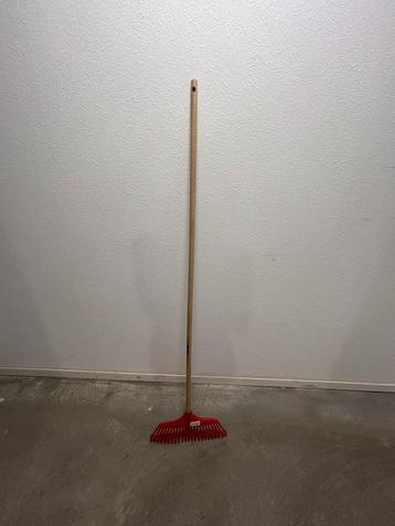 Nieuw ongebruikt blad en gazonhark rood met houtensteel beschikbaar voor biedingen