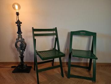 Twee donkergroene houten klapstoelen beschikbaar voor biedingen