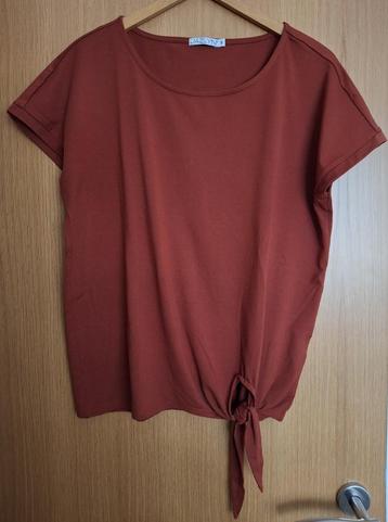 Een roest bruin oranje t-shirt knoopdetail onderaan maat M/L beschikbaar voor biedingen