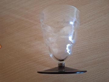 Geëtst waterglas op lichtbruine voet beschikbaar voor biedingen