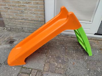 Kleine plastic glijbaan met aansluiting voor tuinslang beschikbaar voor biedingen
