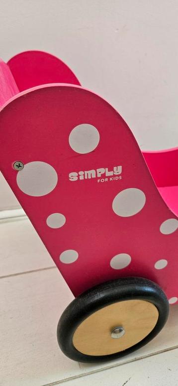 Roze poppenwagen met stippen beschikbaar voor biedingen