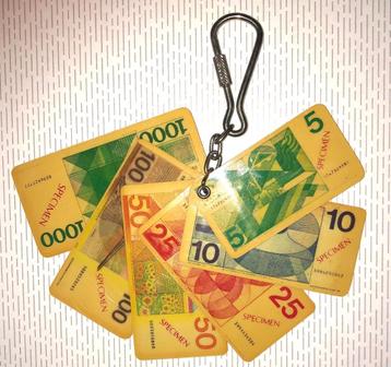 Oude sleutelhanger met gulden bankbiljetjes beschikbaar voor biedingen