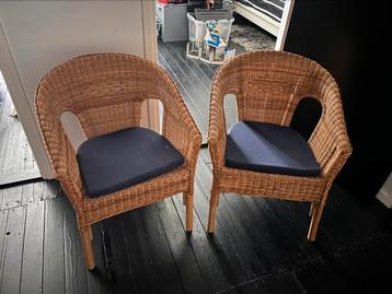 Twee rieten stoelen met donker blauwe zitkussentjes beschikbaar voor biedingen
