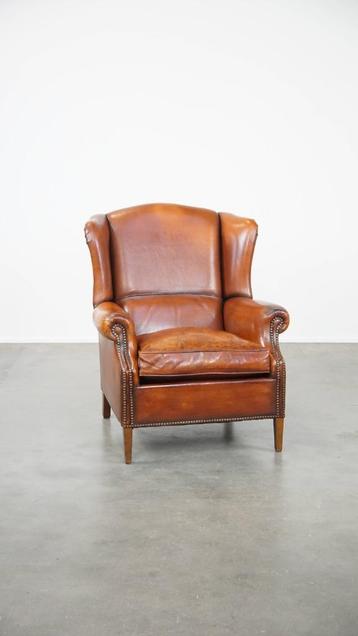 Comfortabele schapenleren oorfauteuil met een mooi patina beschikbaar voor biedingen