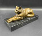 Liggende kat van brons op een marmeren voet.