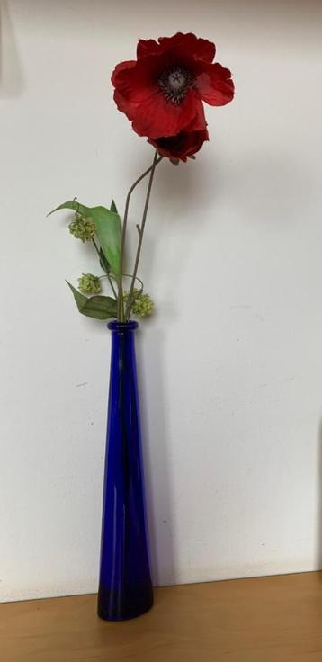 Slanke vaas van blauw glas met kunstbloemen (klaproos) beschikbaar voor biedingen