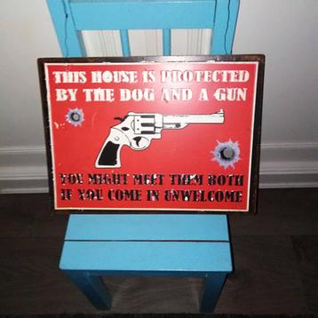 Metalen bord this house is protected by the dog and a gun beschikbaar voor biedingen