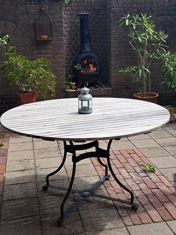 Ronde hardhouten tuintafel met gietijzeren onderstel beschikbaar voor biedingen