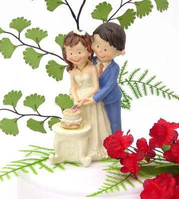 Een zeer leuke bruidspaar, snijden samen hun trouwtaart. beschikbaar voor biedingen